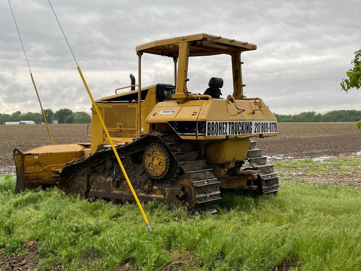Brohez Trucking LLC Cat D6N bulldozer in a central Illinois field with company branding — (217) 809-0779