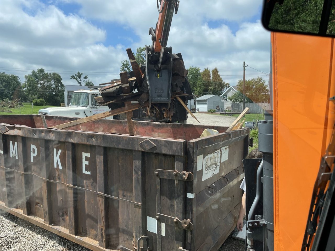 Brohez Trucking excavator with a grapple loading demolition debris into a roll-off box on a central Illinois teardown