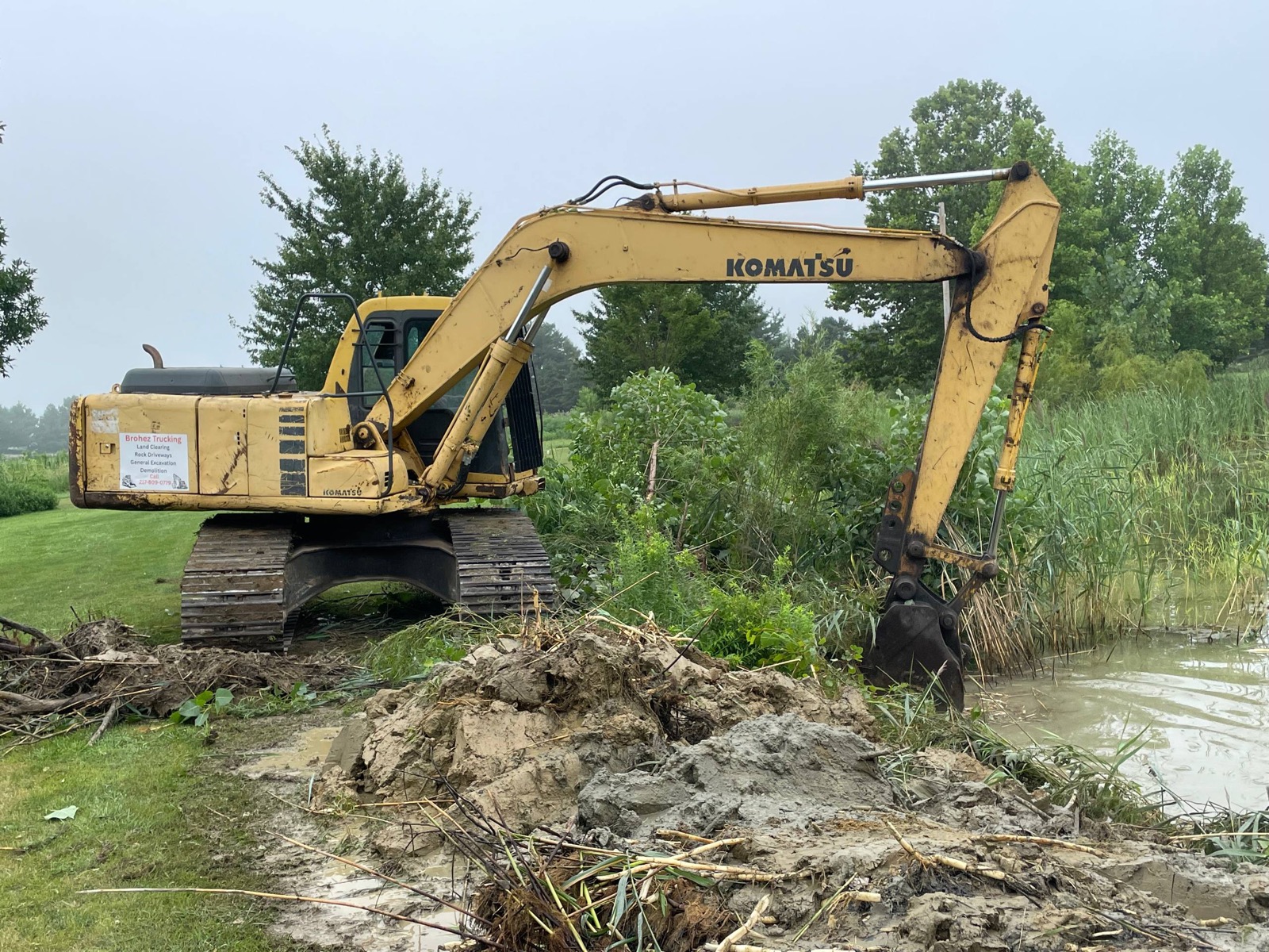 Komatsu PC150 excavator set up on the pond bank at the start of the cleanout near Urbana, Illinois — Brohez Trucking LLC