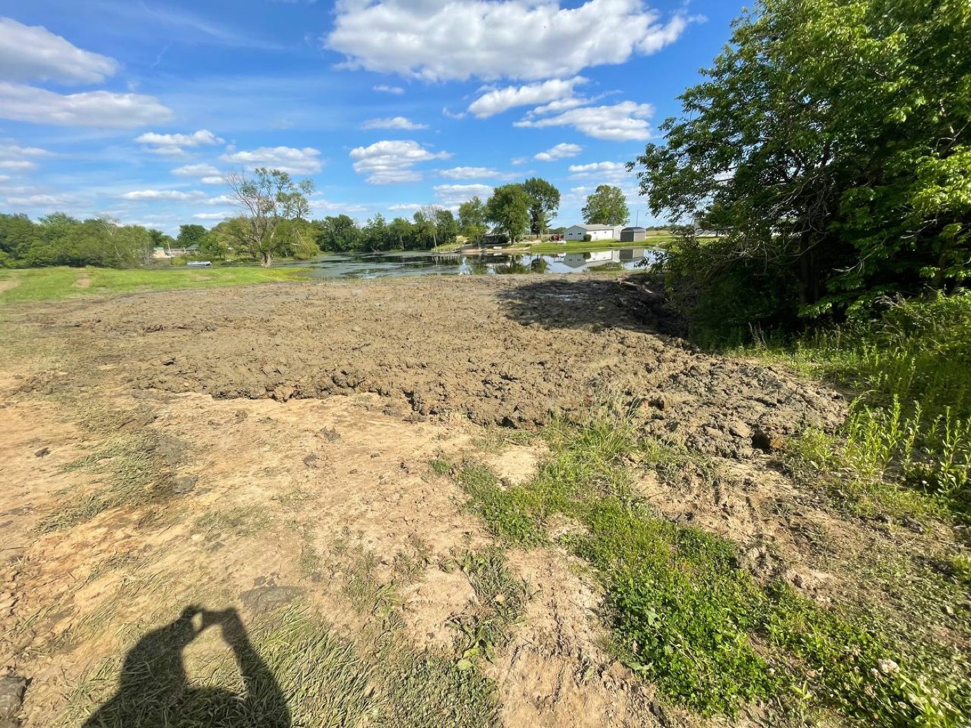 After — restored central Illinois pond with open water and a freshly graded bank by Brohez Trucking LLC